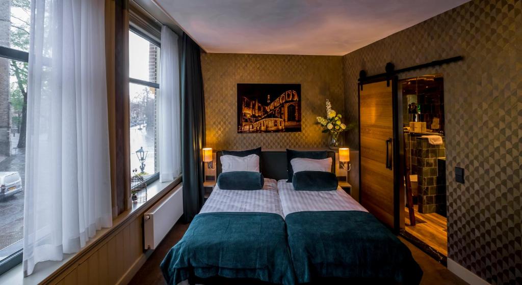 um quarto com uma cama grande e 2 almofadas em Slapen bij hofman em Alkmaar