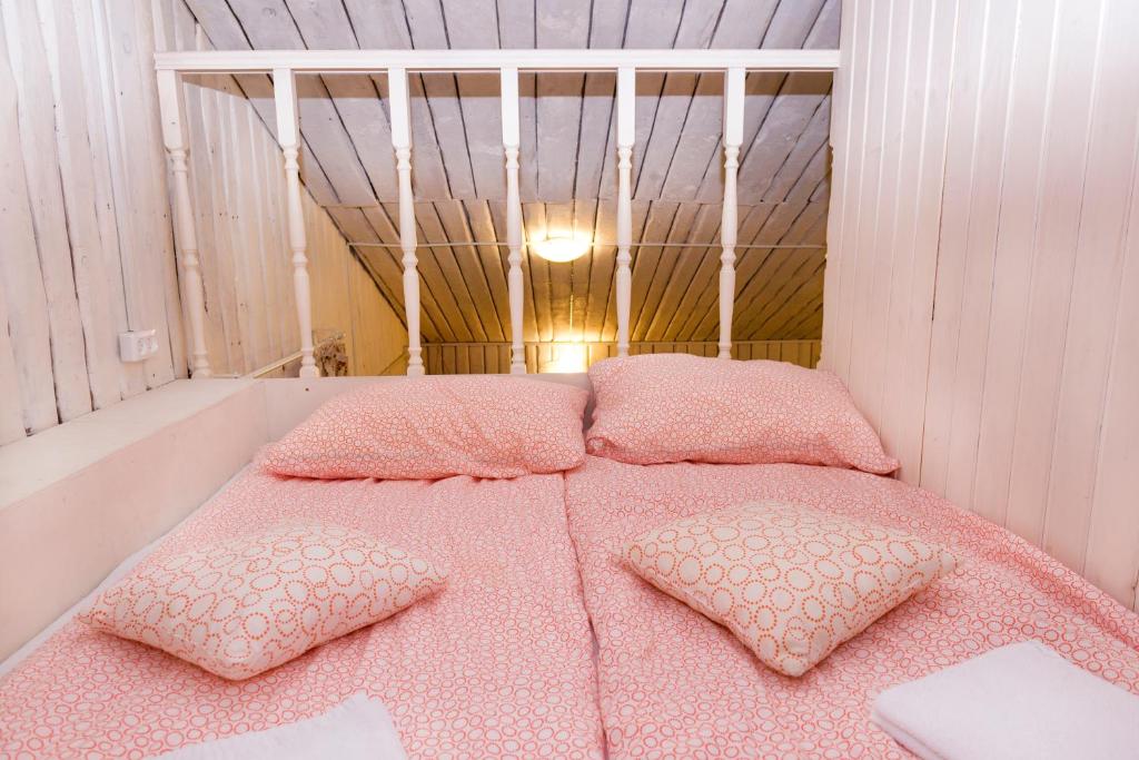 ヴィボルグにあるАпарт-коттедж Fashion-mini с сауной и зоной барбекю в Выборгеのピンクベッド1台、枕2つが備わるベッドルーム1室が備わります。