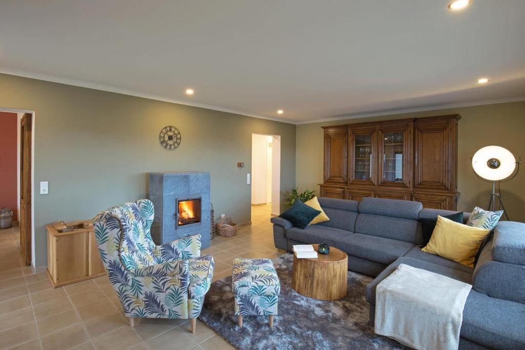 a living room with a blue couch and a fireplace at Ferienwohnung Landblick in Niederlinxweiler