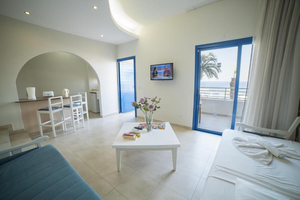 a living room with a couch and a table with flowers on it at MyroAndrou Beach Hotel Apartments in Protaras