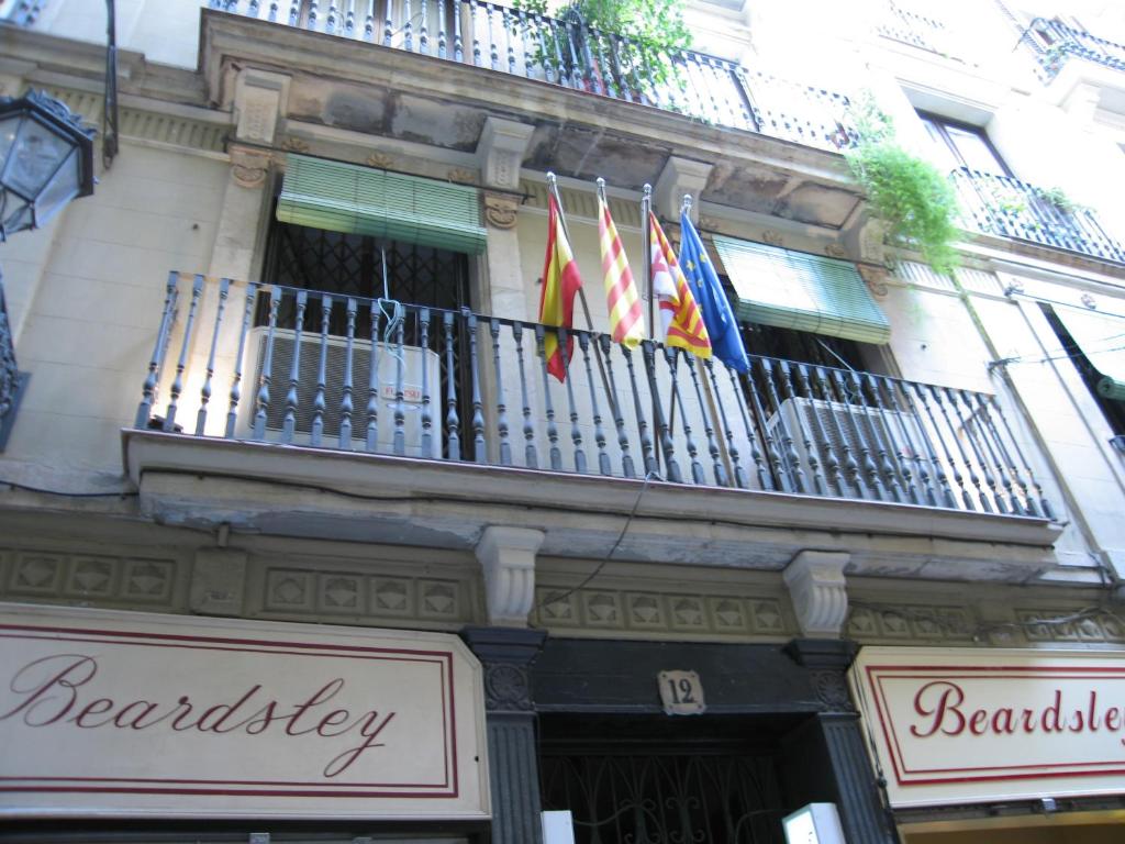 a building with flags hanging from a balcony at PENSIÓN Colmenero in Barcelona