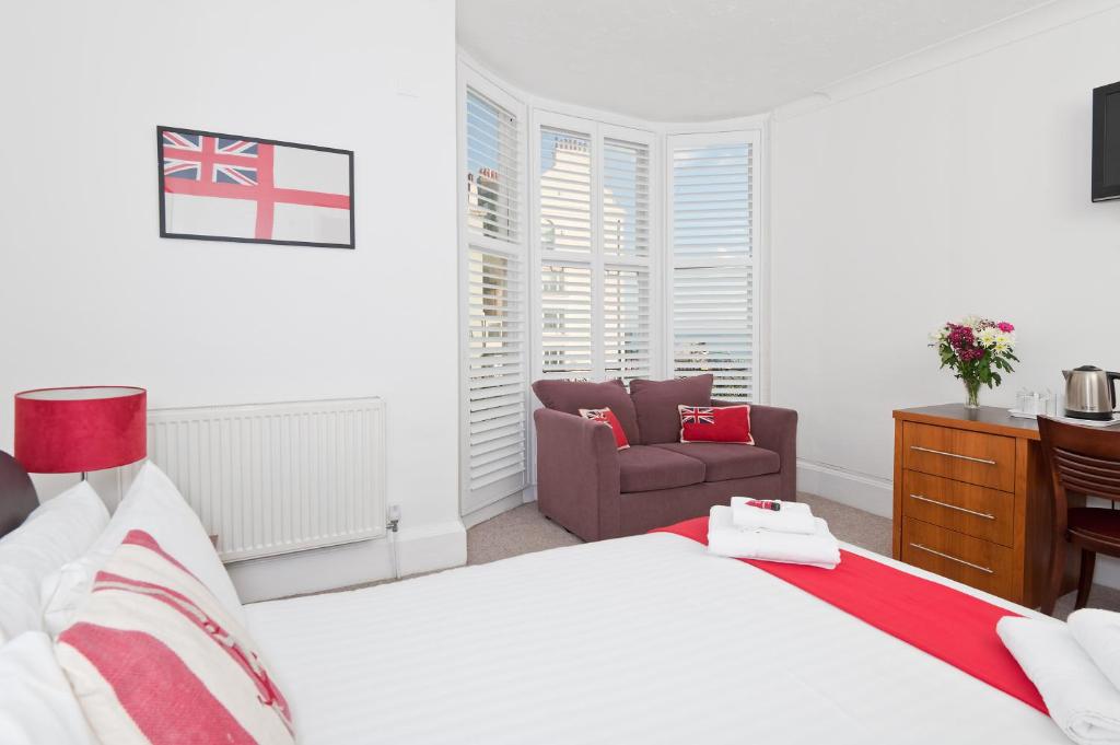 a bedroom with a bed and a chair at Hamptons Brighton in Brighton & Hove