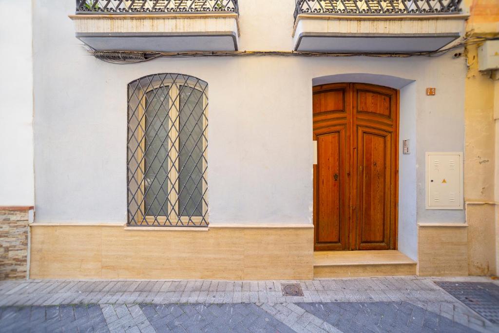 Theodora Chica 1 في مالقة: مبنى فيه باب خشبي ونافذة