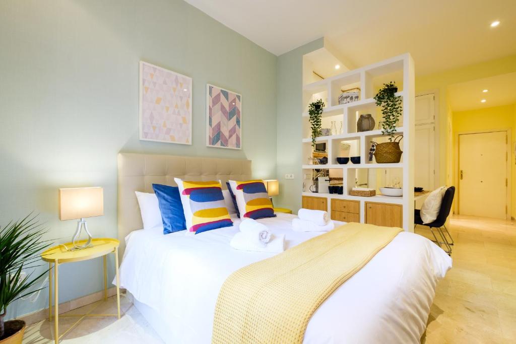 マドリードにあるMy City Home Estudio en Malasañaのベッドルーム(大きな白いベッド、カラフルな枕付)