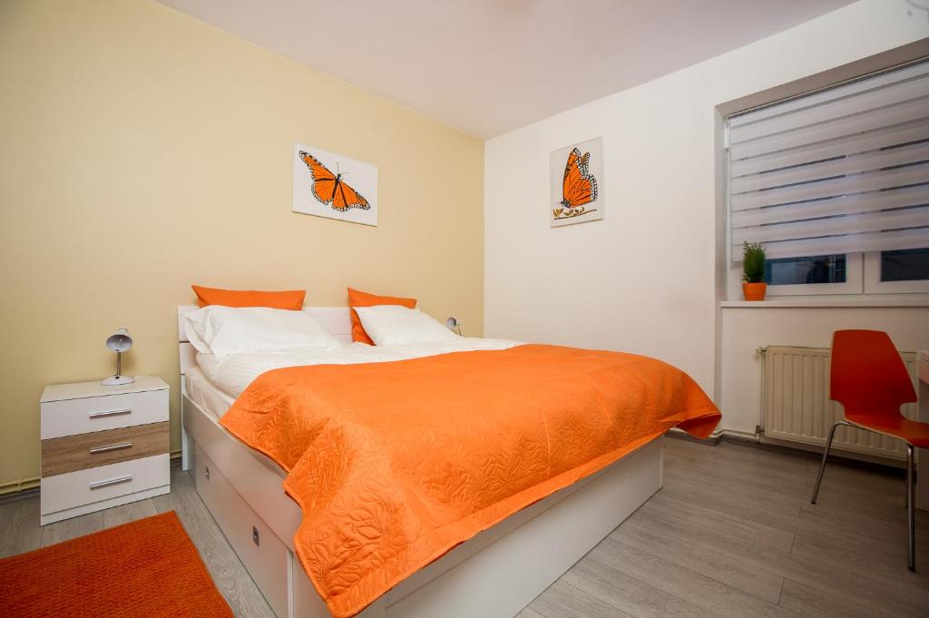1 dormitorio con 1 cama con manta naranja en Roze Apartment, en Zagreb