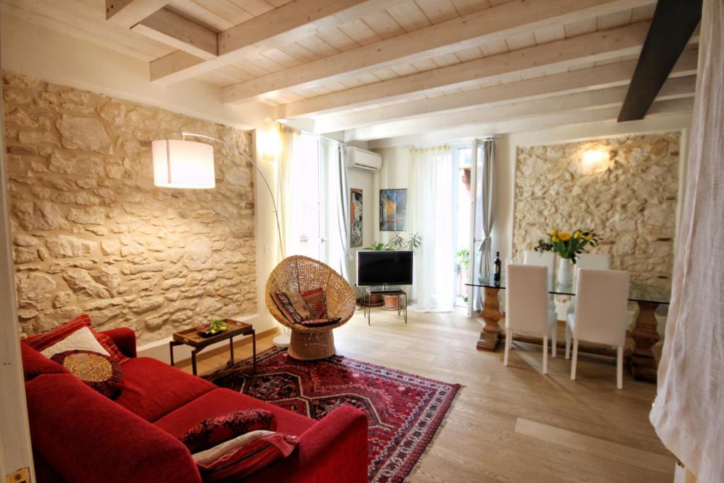 salon z czerwoną kanapą i kamienną ścianą w obiekcie Casa Angie w Weronie