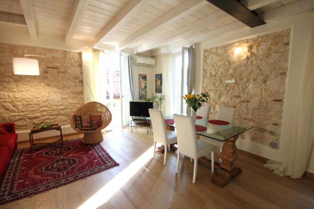 salon ze stołem i kamienną ścianą w obiekcie Casa Angie w Weronie