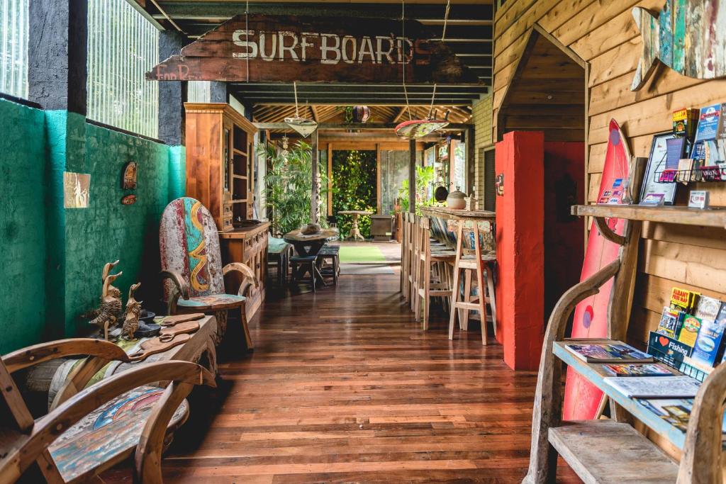 Albany Bali Style Accommodation في ألباني: محل لركوب الأمواج مع طاولات وكراسي في غرفة