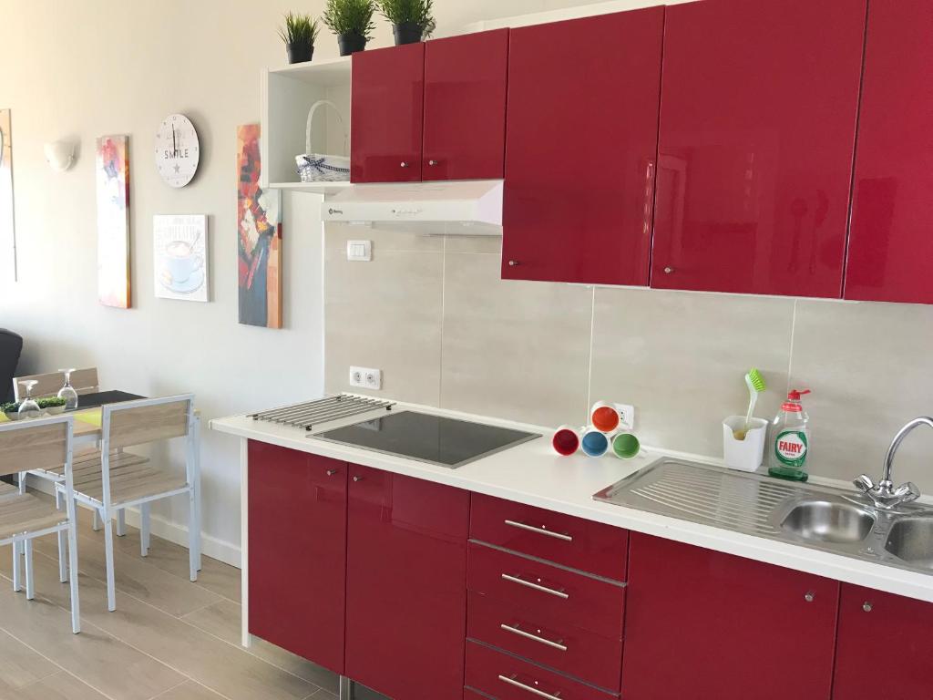 - une cuisine avec des placards rouges et un évier dans l'établissement Caleta Beach Deluxe, à Caleta de Fuste