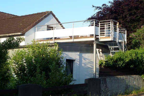 ein weißes Haus mit einem Balkon an der Seite in der Unterkunft Ferienhaus Kassiopeia in Laboe