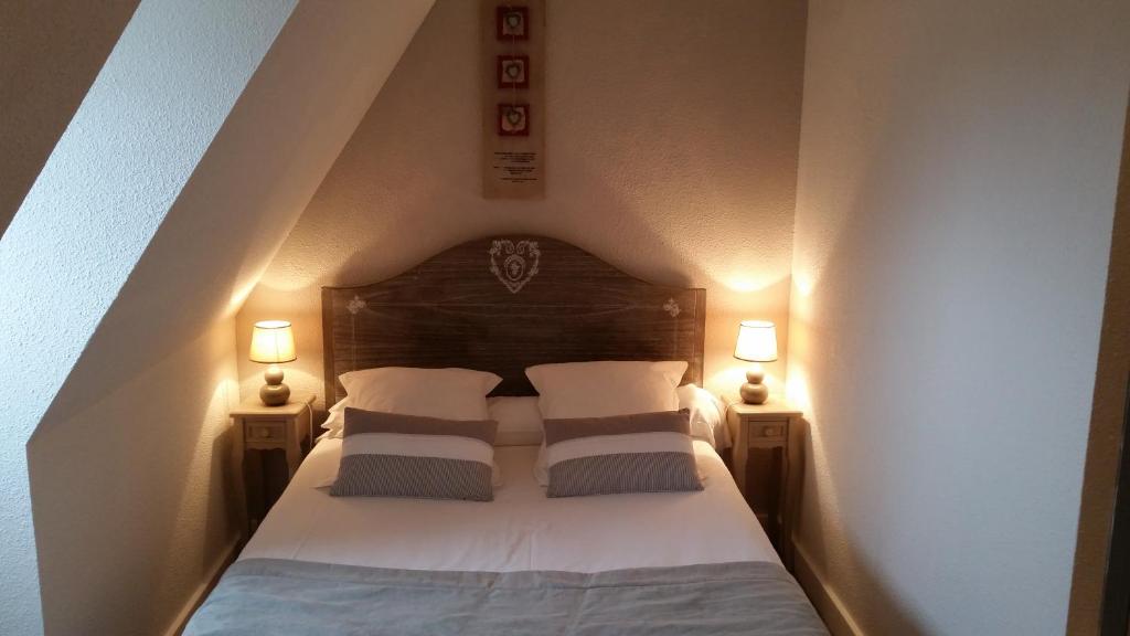 - une chambre avec un lit avec deux oreillers et deux lampes dans l'établissement Amadour Hôtel, à Rocamadour