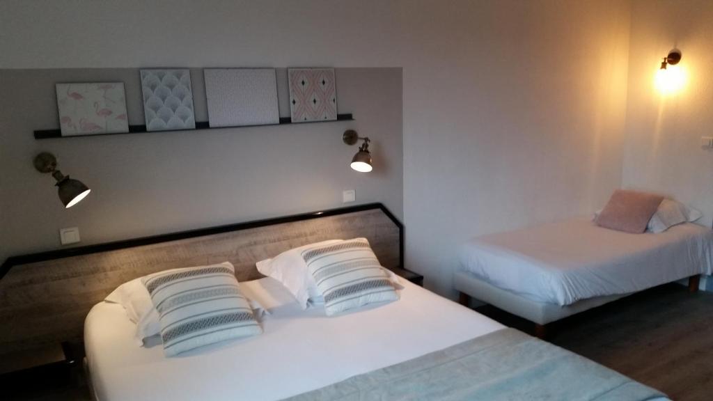 Llit o llits en una habitació de Amadour Hôtel