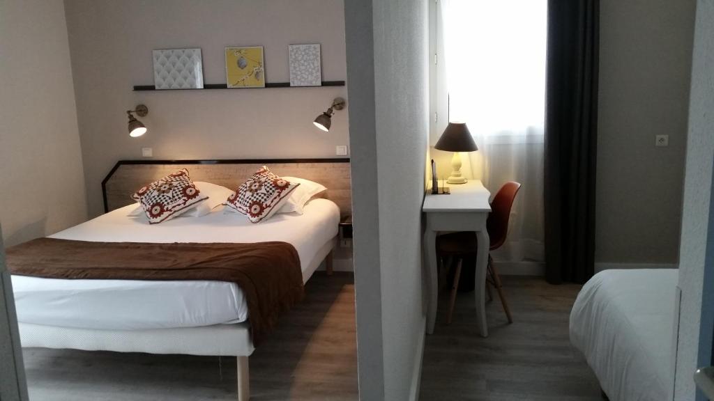 Llit o llits en una habitació de Amadour Hôtel