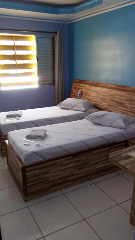 a large wooden bed in a bedroom with a window at Hotel Carpe Diem in Sao Paulo