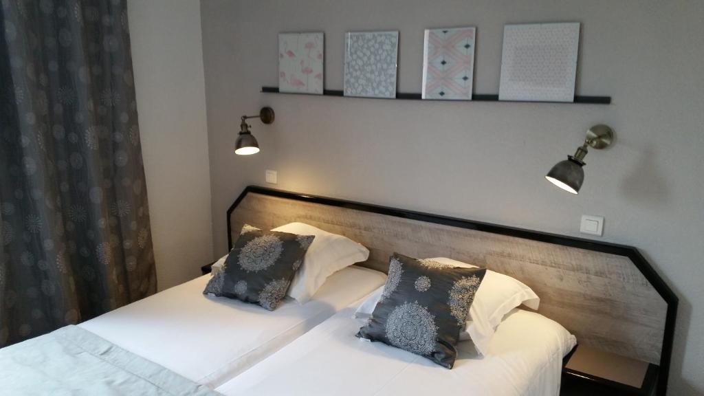 Llit o llits en una habitació de Amadour Hôtel