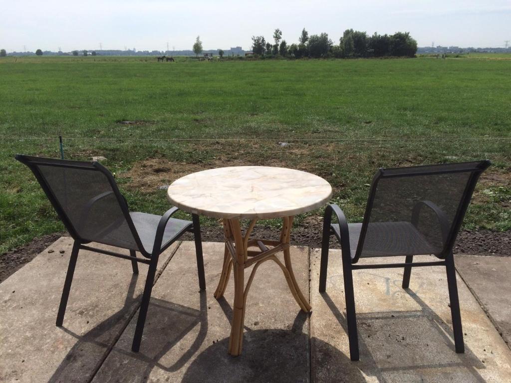 a table and two chairs with a table and a field at Your nice waggon at the Cow's Paradise in Amsterdam