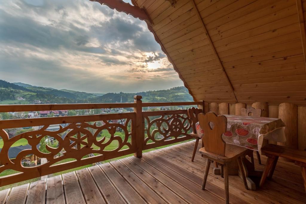 porche de madera con mesa y sillas en el balcón en Góralska Chata Pieniny en Krościenko