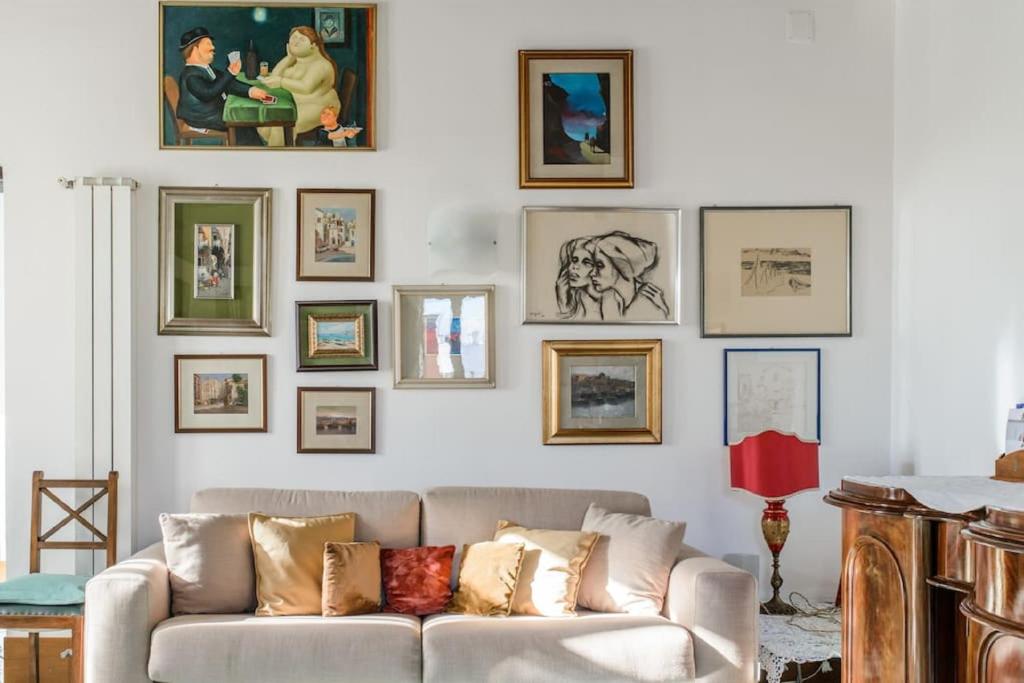 a living room with a couch and pictures on the wall at Naples Center Apartment in Naples