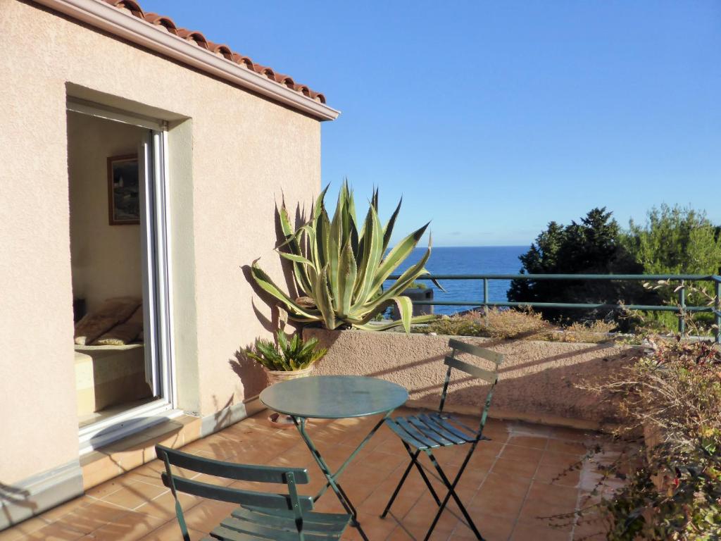 un patio avec deux chaises et une table sur un balcon dans l'établissement 4SAP22 Appartement climatisé avec double terrasses, à Collioure