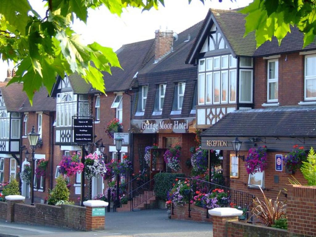 una fila de casas con flores delante de ellas en Grange Moor Hotel en Maidstone