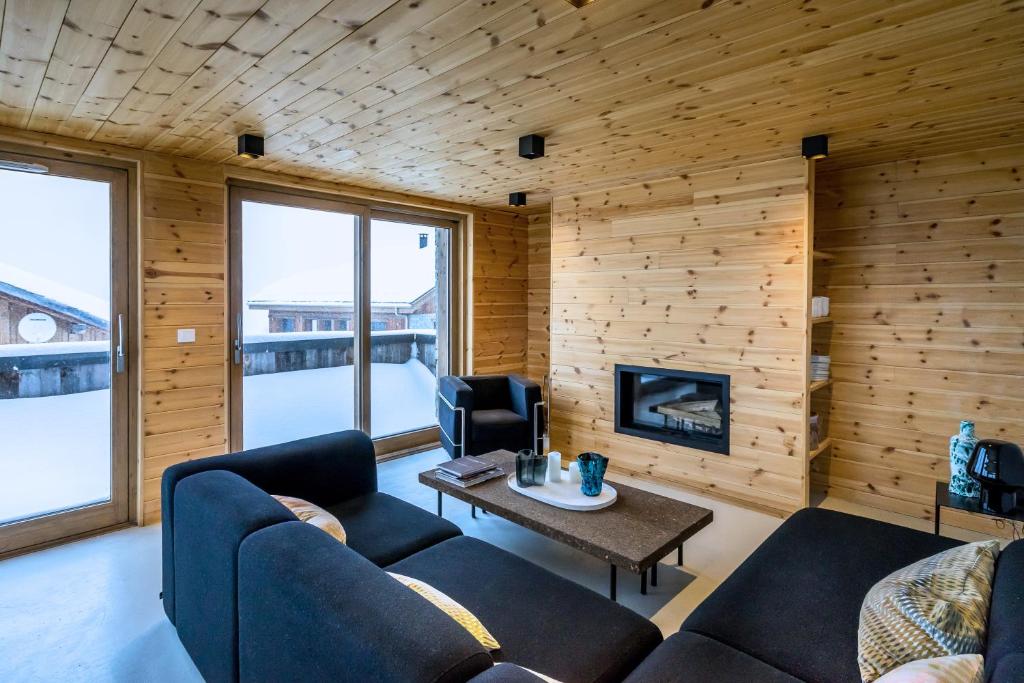 a living room with two couches and a fireplace at Home by U - Chalet 3 in Saint-Martin-de-Belleville