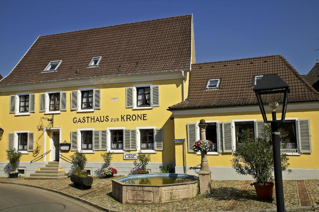 un edificio amarillo con una señal para una casa en Krone Britzingen, en Müllheim