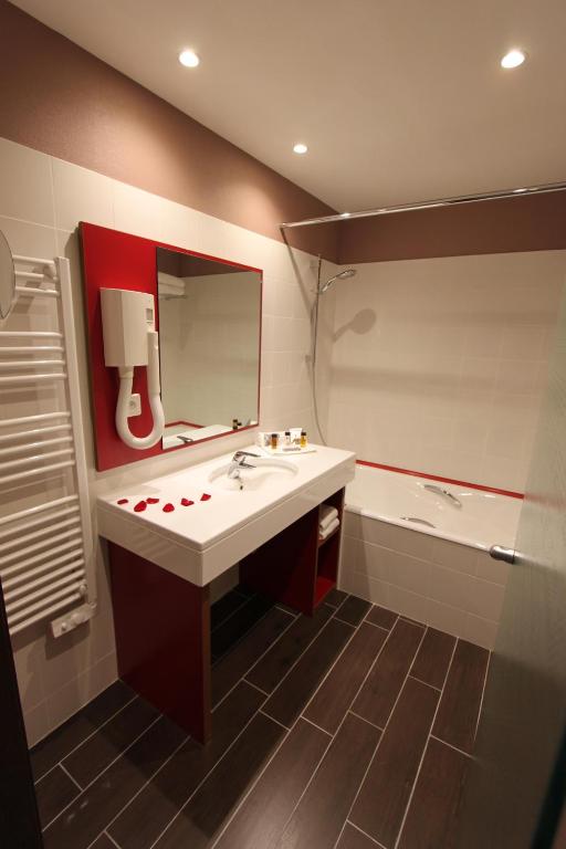uma casa de banho com um lavatório, um espelho e uma banheira em Hotel Lyon-ouest em Lyon