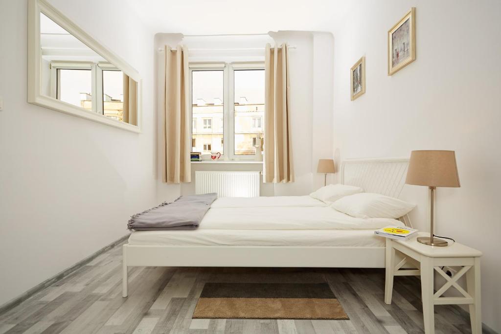 ワルシャワにあるMarszałkowska Apartamentの白いベッドルーム(ベッド1台、窓付)