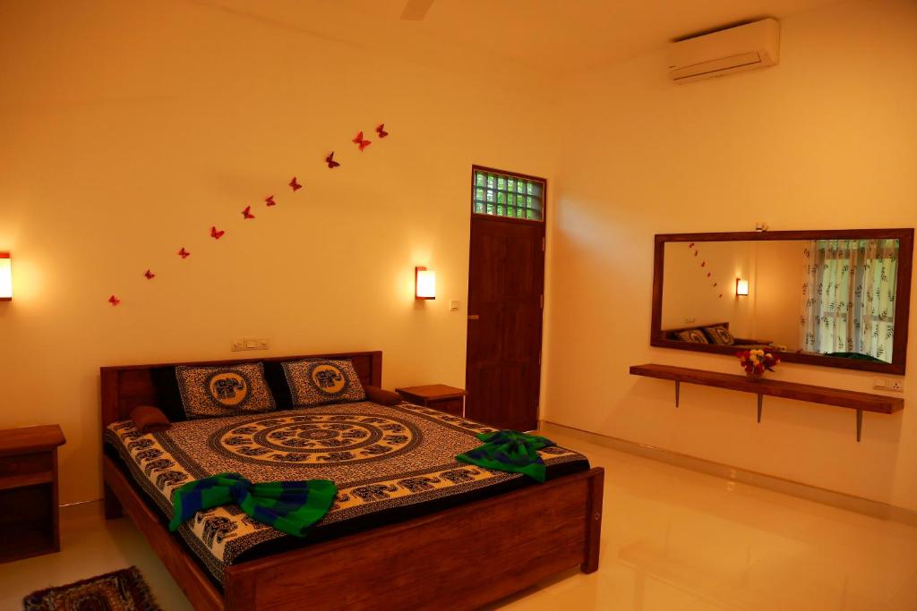 a bedroom with a bed and a large mirror at Shine Park in Tissamaharama