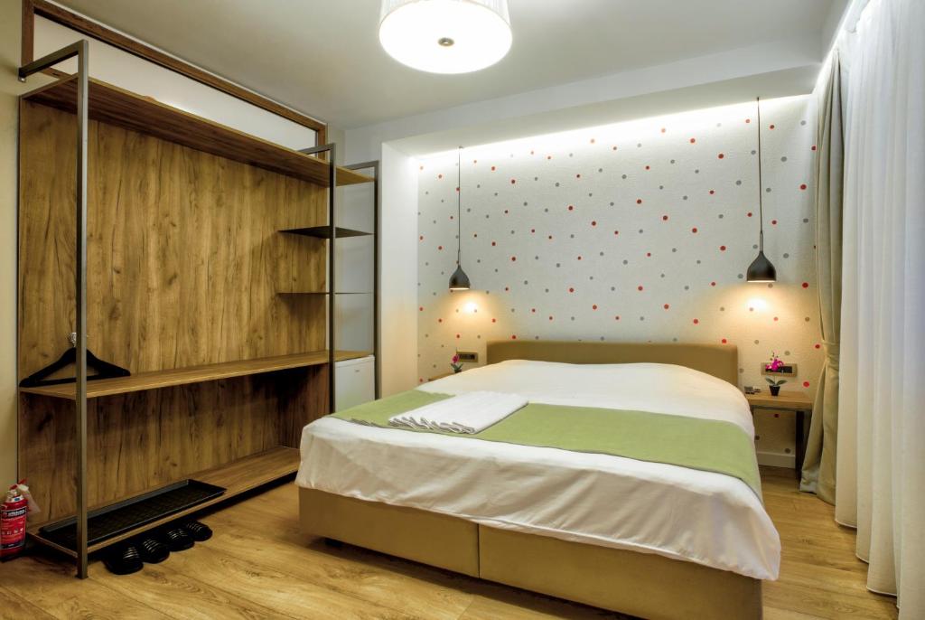 a bedroom with a bed and a wall with polka dots at Boulevard Prishtina in Pristina