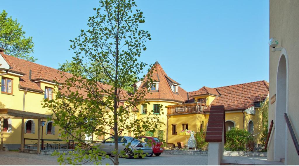 Pension Himmelreich في Ternitz: مبنى اصفر فيه سيارات تقف امامه