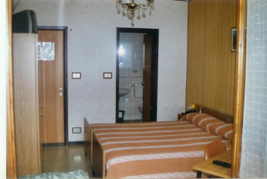 a reflection of a room with a bed and a mirror at Dufour Hotel in Châtillon