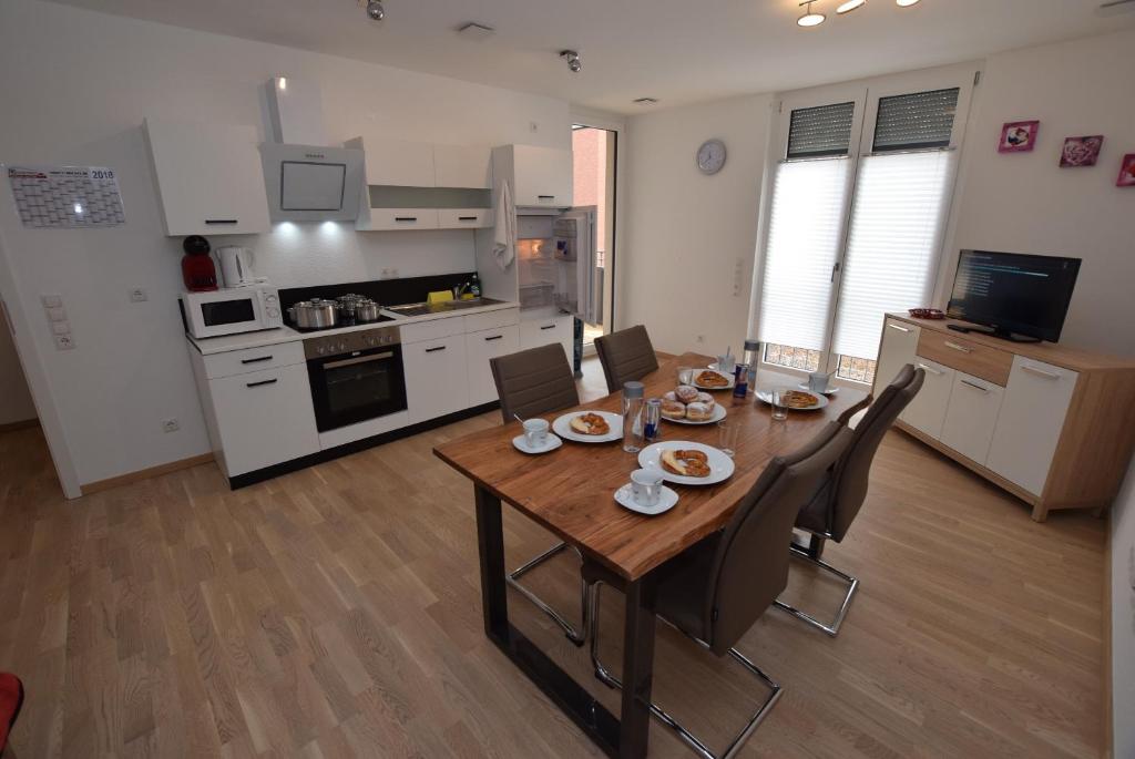 uma cozinha e sala de jantar com mesa e cadeiras em AB Apartment Kornwestheim em Kornwestheim