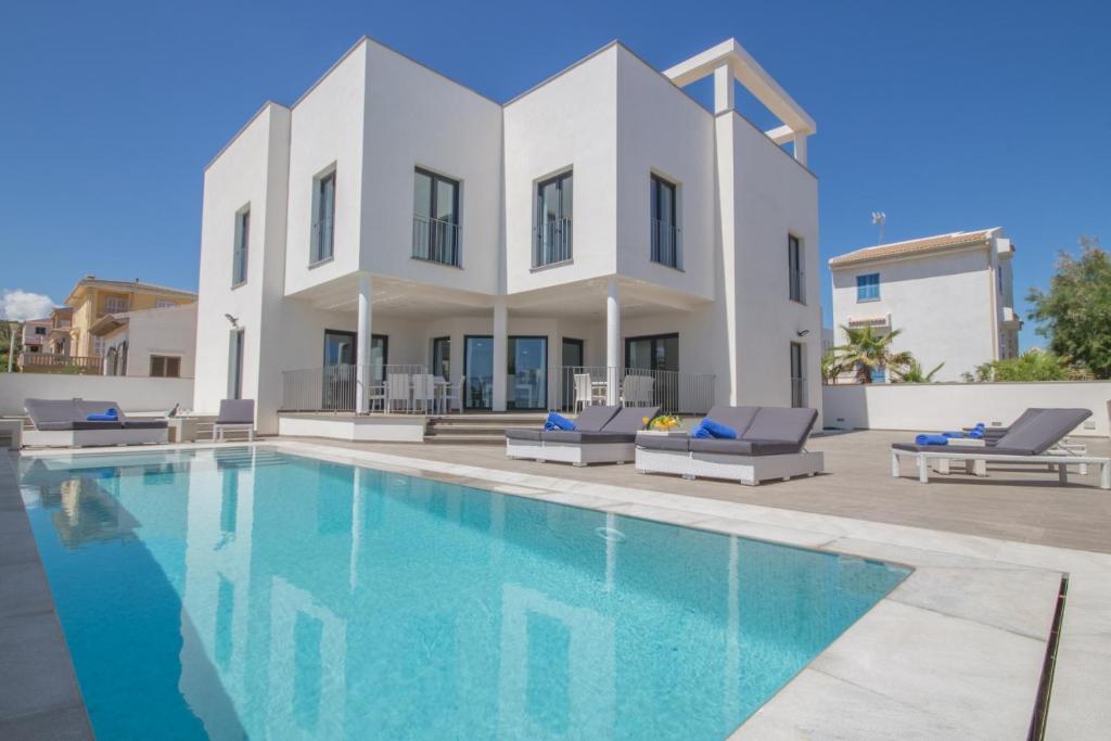 a villa with a swimming pool in front of a house at Son Serra de Marina - 1930-45 Mallorca in Son Serra de Marina