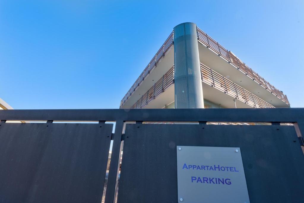 AppartaHotel في Beinasco: علامة وقوف السيارات أمام المبنى