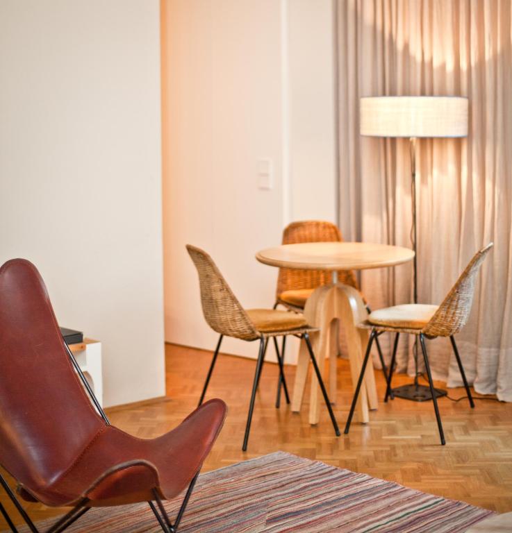 a room with a table and chairs and a lamp at CORTIINA Hotel in Munich