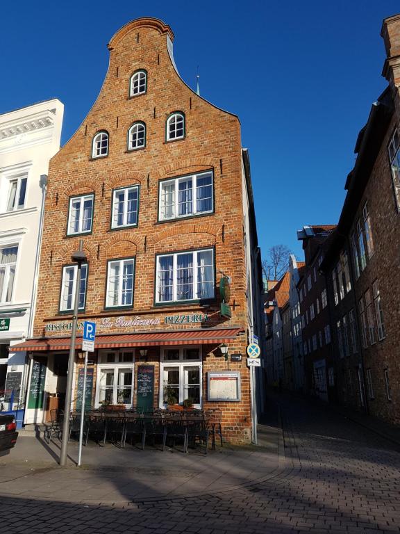 ein großes Backsteingebäude in einer Stadtstraße in der Unterkunft Appartementhaus Obertrave in Lübeck