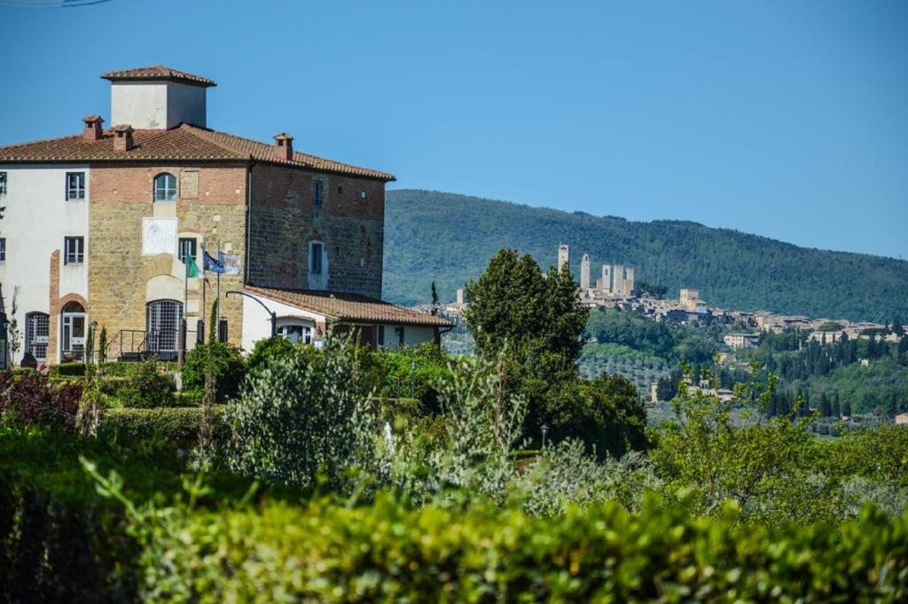 a building on a hill with a city in the background at Castello di Fulignano Soarzio panoramic apartment in San Gimignano