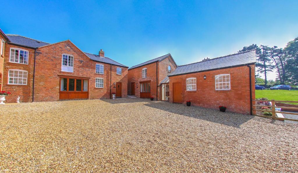 a large brick building with a driveway in front of it at Westfield Country Barns in Braunston