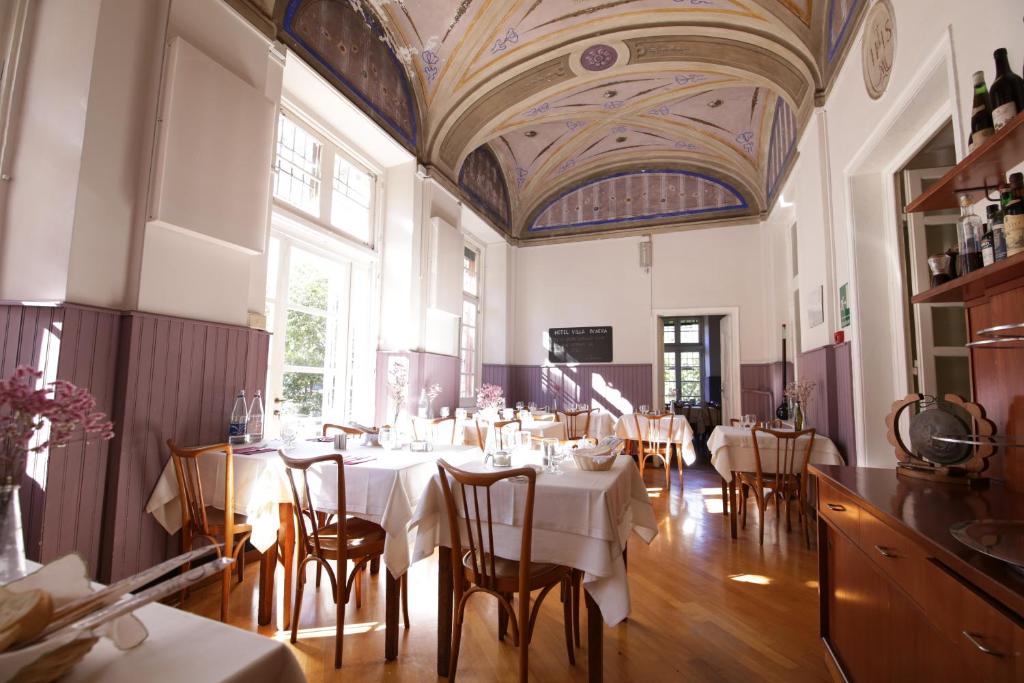 Un comedor con mesas y sillas y un techo en Hotel Villa Bonera, en Génova