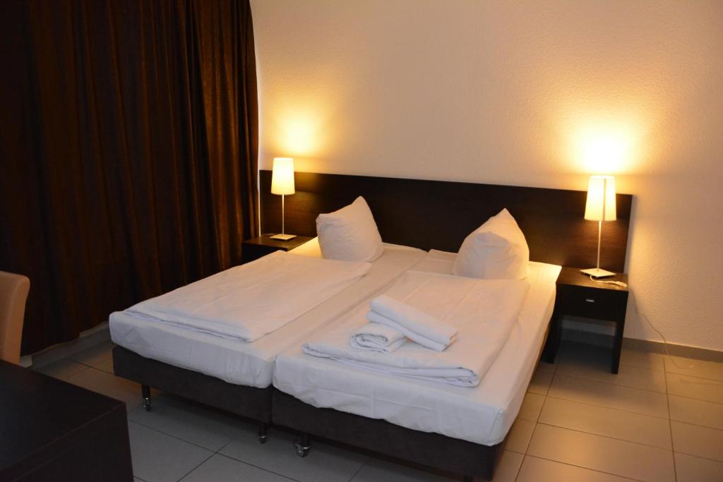 ein Hotelzimmer mit einem Bett mit Handtüchern darauf in der Unterkunft Mosel Hotel in Frankfurt am Main