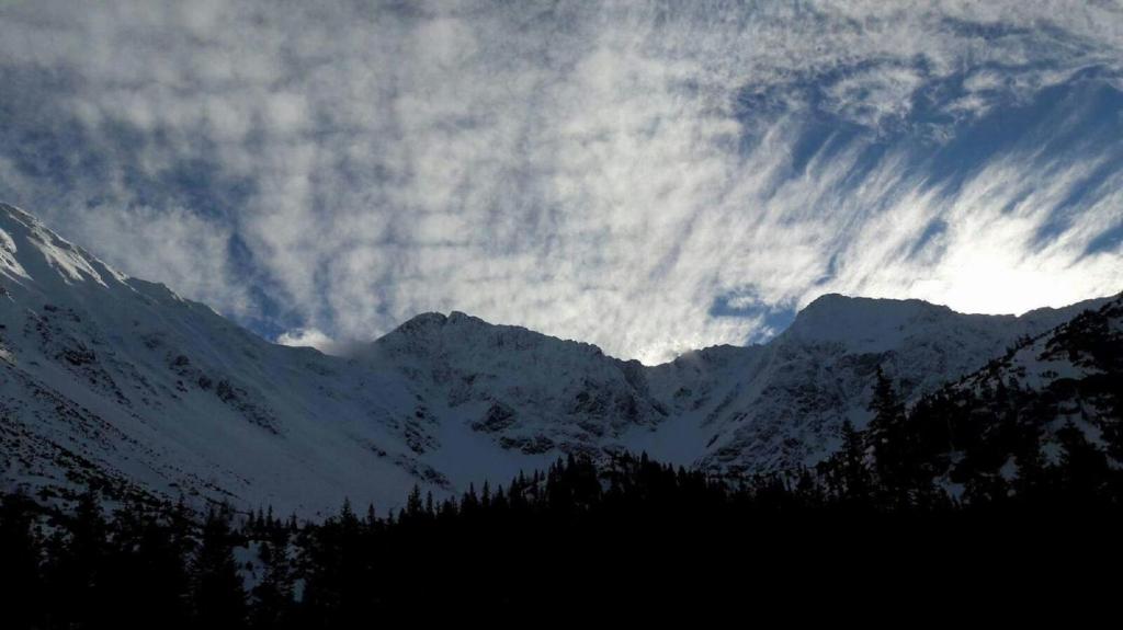 a cloudy sky over a snow covered mountain at Apartmány Grobarčík in Zuberec