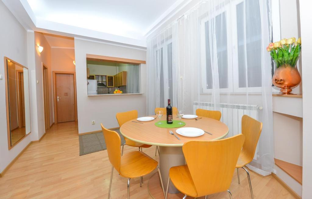 een eetkamer met een tafel en gele stoelen bij Marlin Apartments Unirii Square in Boekarest