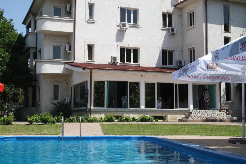 um edifício com piscina em frente a um edifício em Hotel Paradis em Slatina