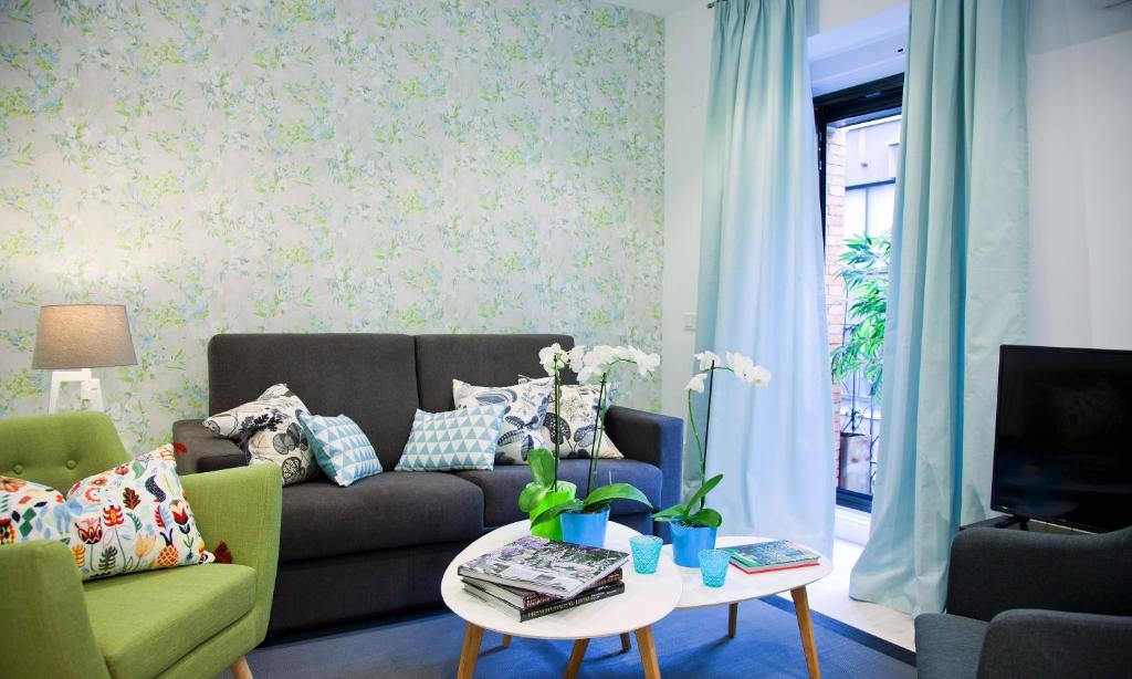 uma sala de estar com um sofá e uma mesa em Feelathome Madrid Suites Apartments em Madri