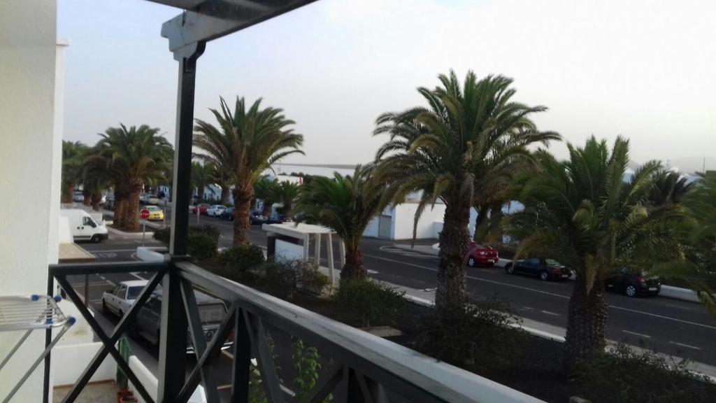 a view of a street with palm trees from a balcony at Apartamento en el pueblo de Arrieta 3 in Arrieta