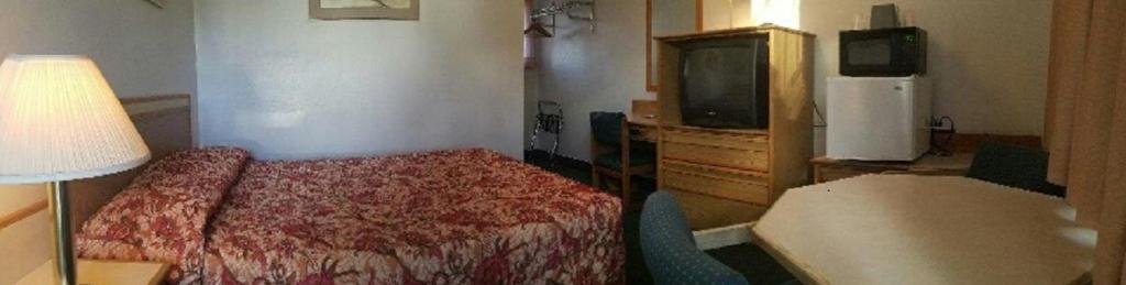 
a hotel room with a bed and a television at Oregon Trail Motel and Restaurant in Baker City
