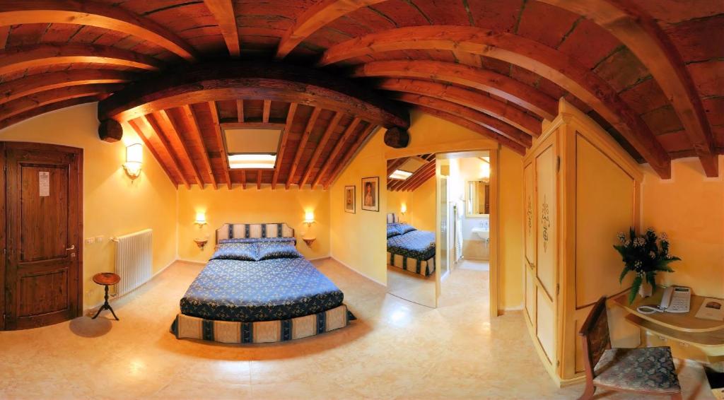 a bedroom with a large bed with a wooden ceiling at Locanda Modigliani in Ferrara