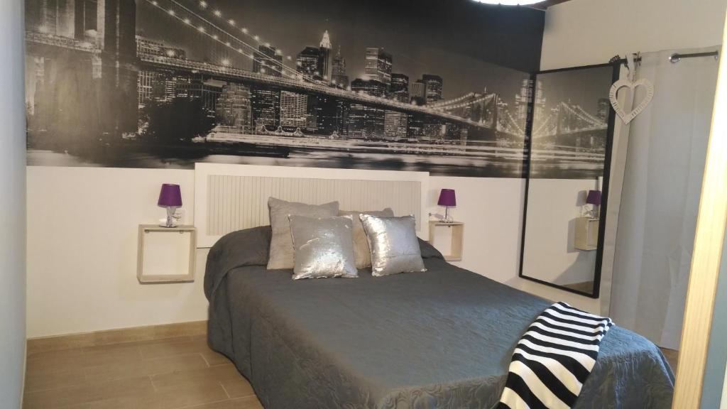 - une chambre dotée d'un lit avec une photo sur le mur dans l'établissement Apartamento Ayla, à Playa Quemada