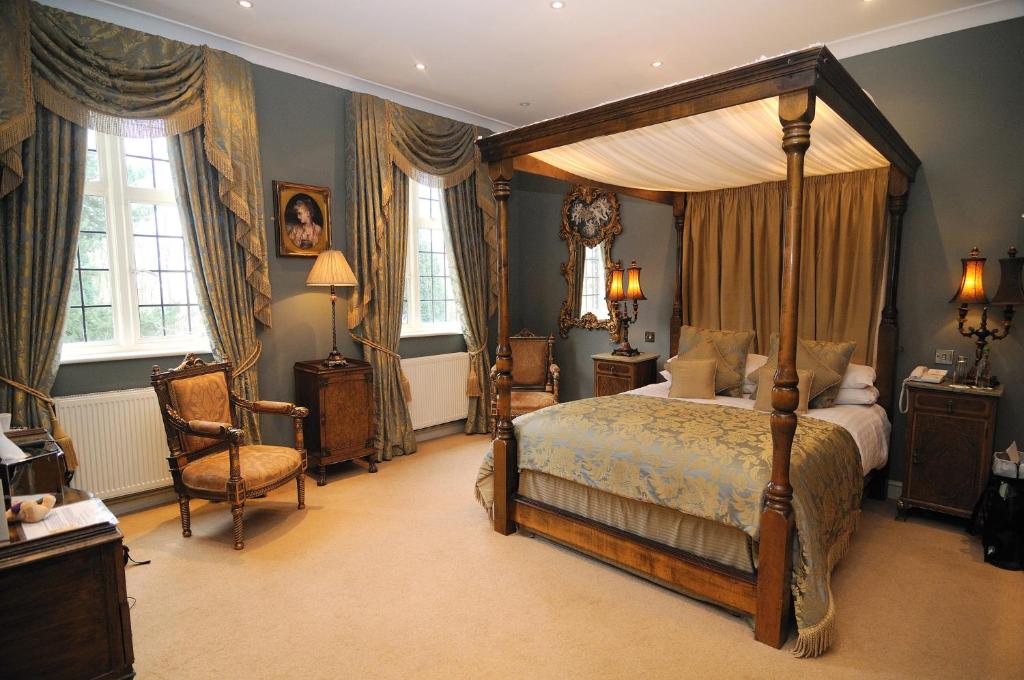 1 dormitorio con cama con dosel y silla en Ye Olde Bell Hotel & Spa, en Retford